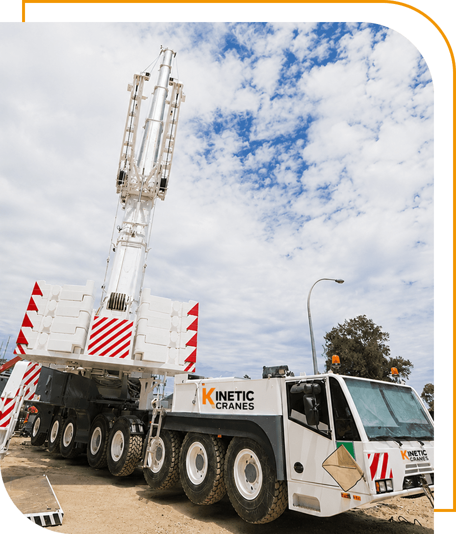 Mobile crane with extended boom under blue sky.